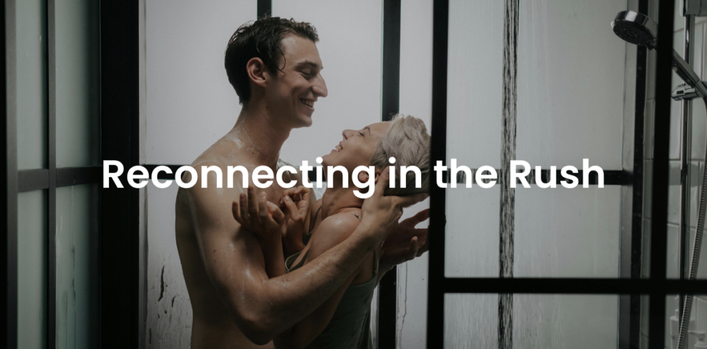 A couple shares an intimate moment in a shower, embracing and smiling at each other with warmth and connection. The text overlay reads "Reconnecting in the Rush," symbolizing finding closeness and emotional intimacy amidst a busy life.